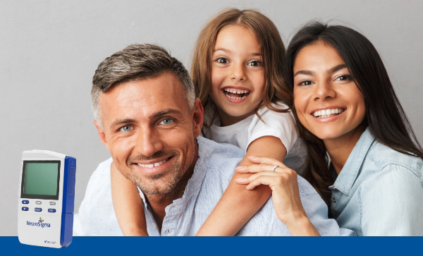 A family smiling and hugging behind a monarch etns system device